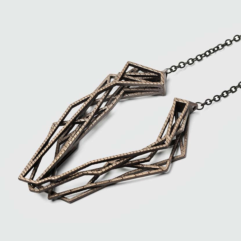 Long bronze necklace with geometric pendant.