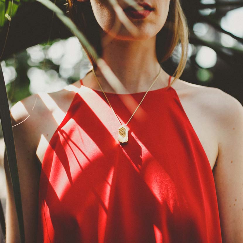 Architecture necklace with woman wearing red dress.