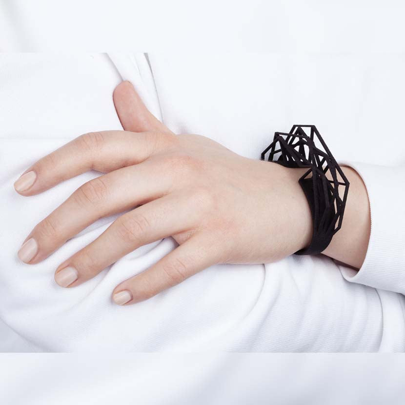 Black cuff bracelet on wrist of woman.