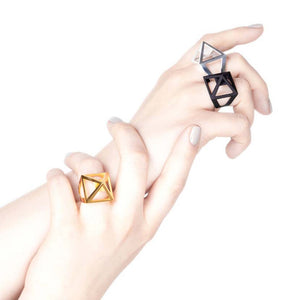 Black pyramid ring with silver and gold on elegant hands.