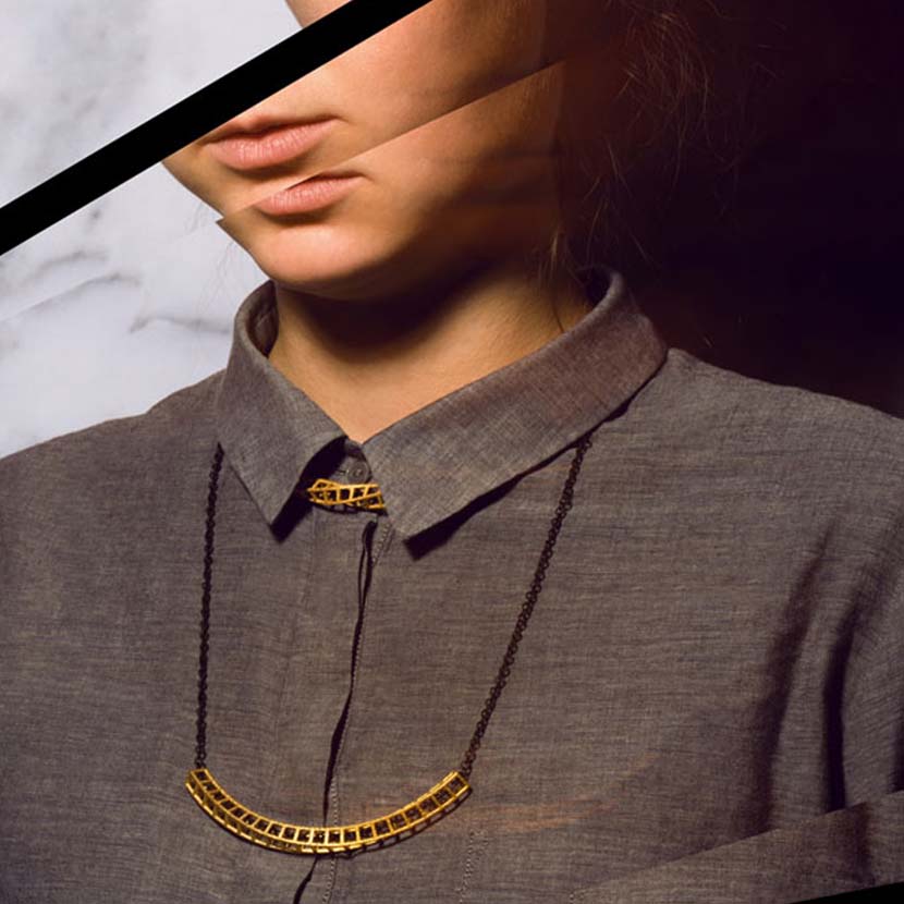 Gold double necklace on woman with blouse.