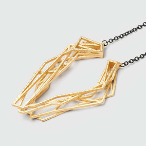 Gold geometric pendant with chain necklace.