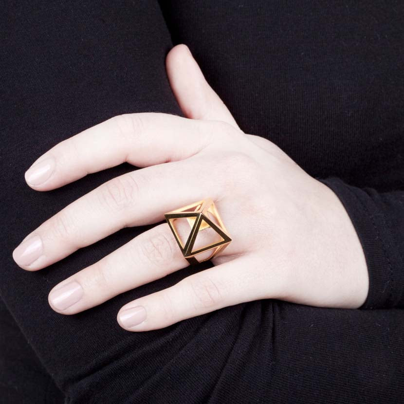 Gold pyramid ring on hand looks Egyptian.