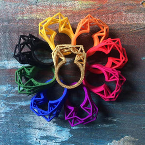 A large black ring as part of jewelry in rainbow colors.