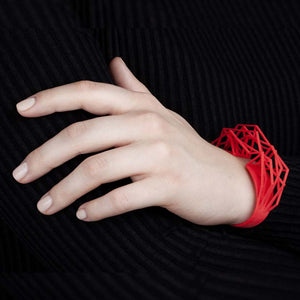 A large cuff bracelet in coral red.