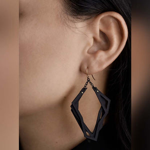 Lightweight black earrings hanging from ear.