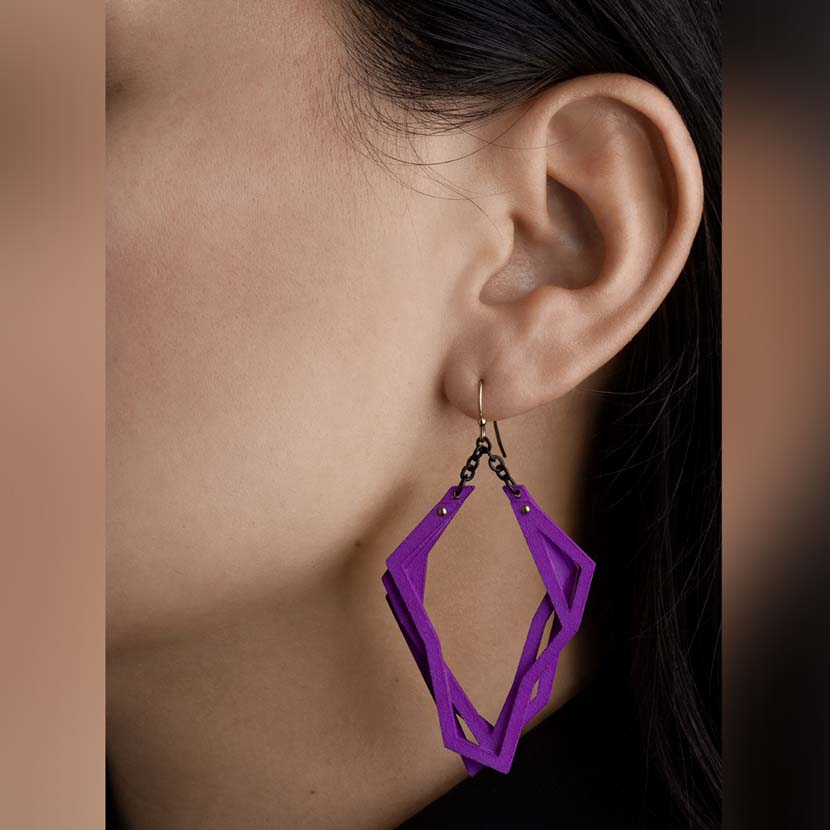 Lightweight statement earrings purple color hanging.