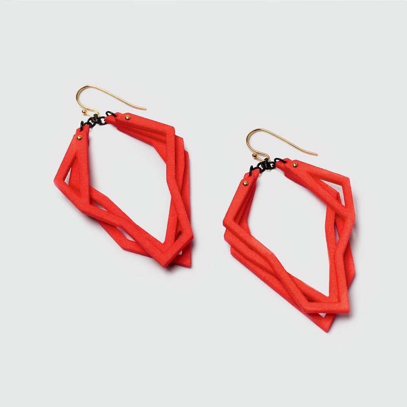 Lightweight statement earrings in coral red.