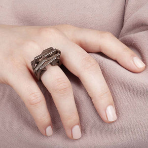 Modern bronze ring on finger of woman.