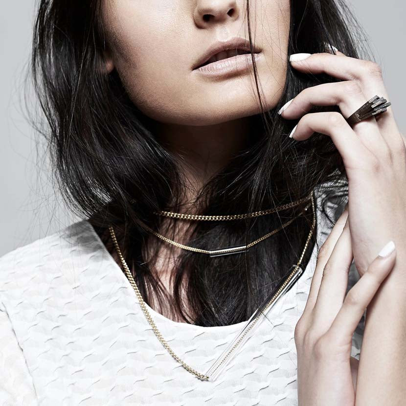 Dark haired model wearing a modern bronze ring.