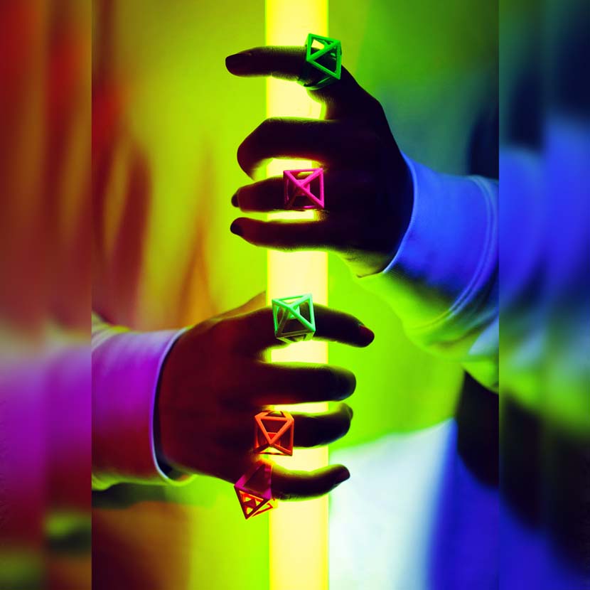 Neon jewelry on girl with colorful nails.