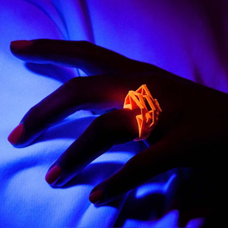 Stylish neon orange ring shown under black light.