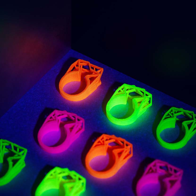 A neon yellow ring with other neon rings illuminated by blacklight.