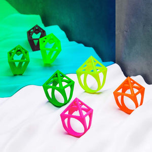 Pink pyramid ring together with green, yellow and orange rings.