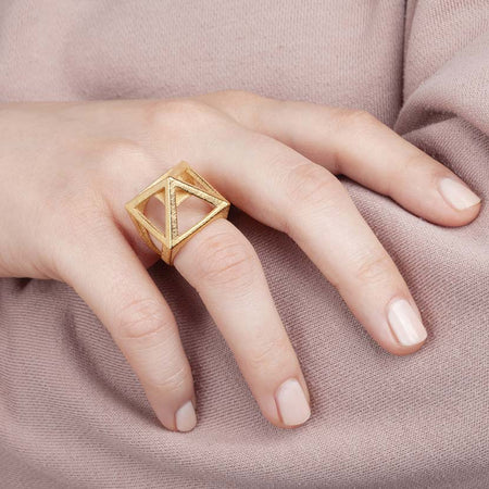 Pyramid ring held by woman.
