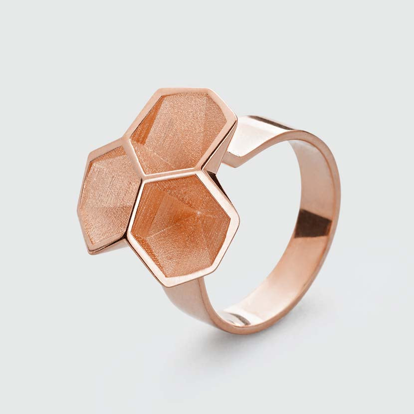 Rose gold honeycomb ring with facets.