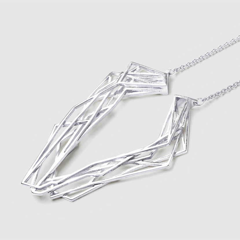 Silver geometric necklace with intricate design.